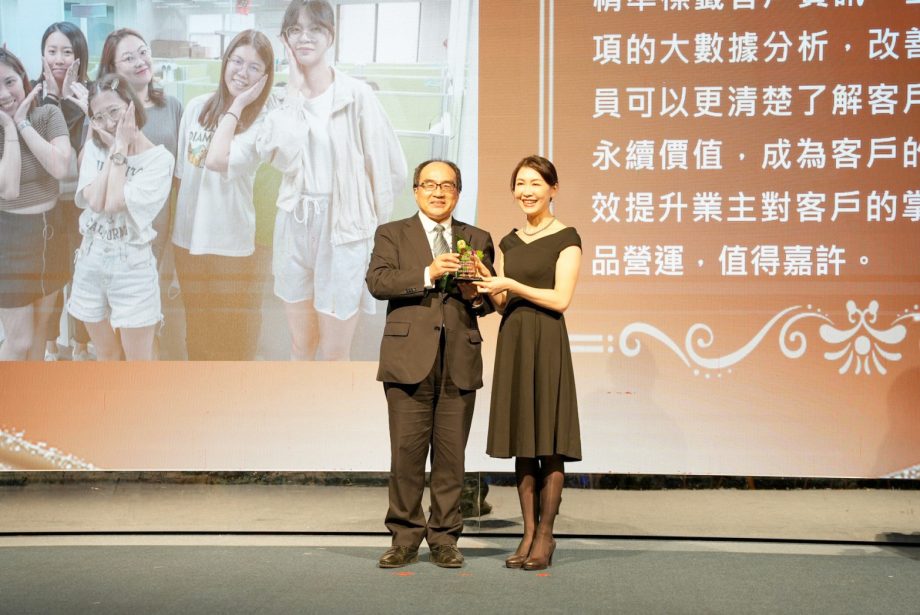 程曦資訊總經理賴媖美（右），由行政院數位產業署呂正華署長 (左)手中接過獎盃。